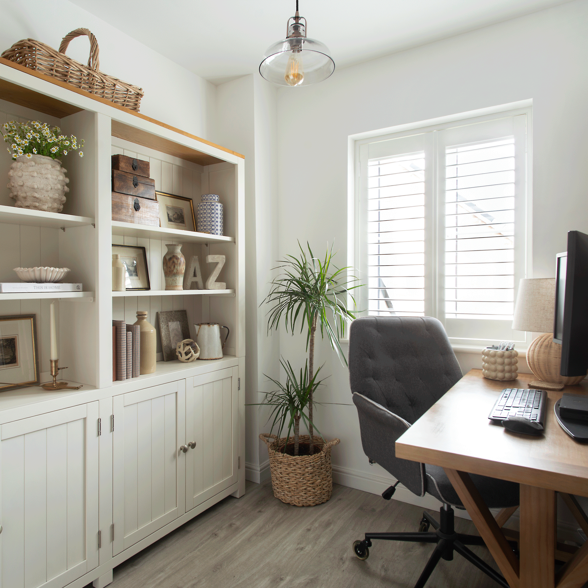 a neutral home office room with a country style bookcase and a large upholstered office chair