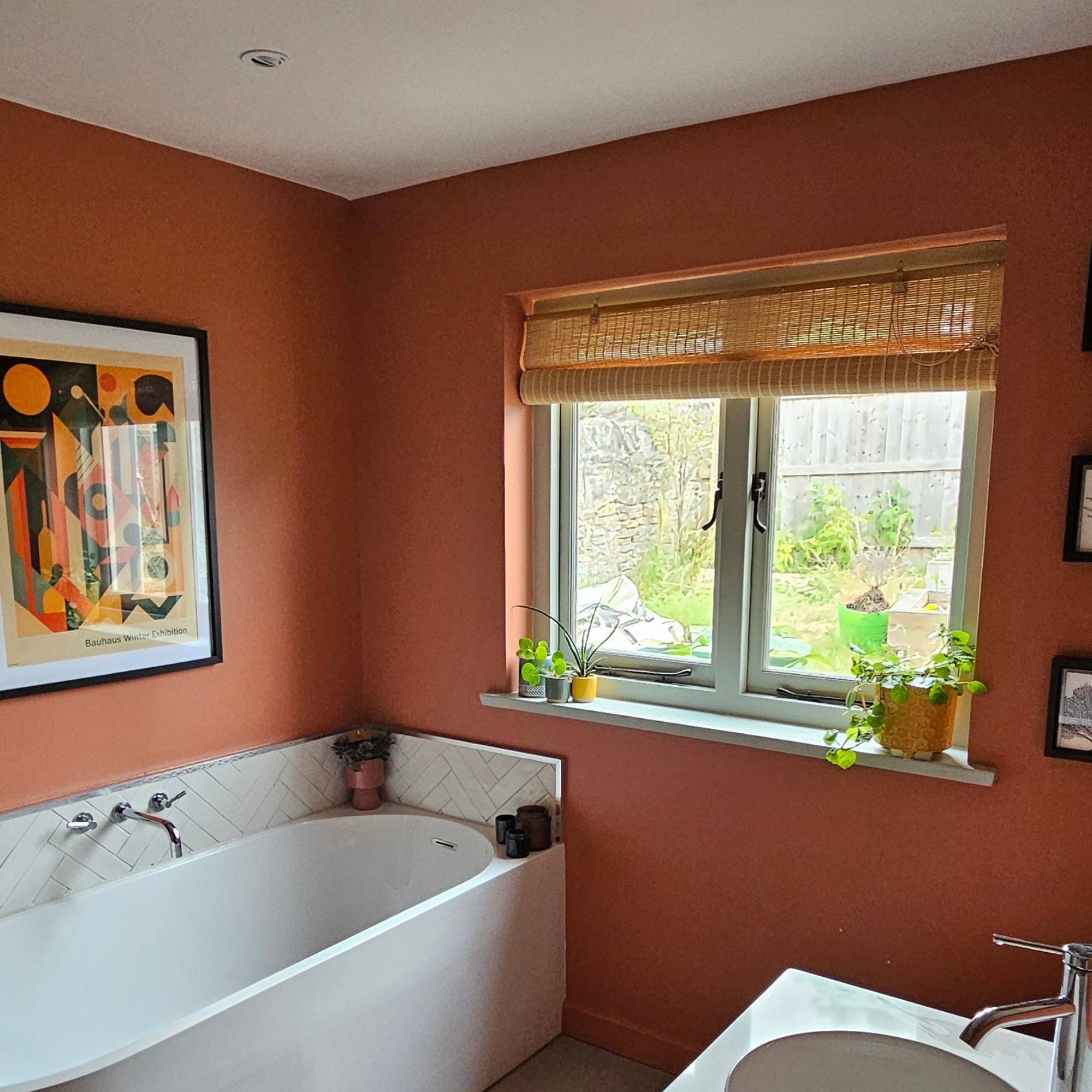 red bathroom with white bath and blue windows
