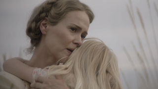 A still from the movie Hold your Breath showing Sarah Paulson holding a small child.