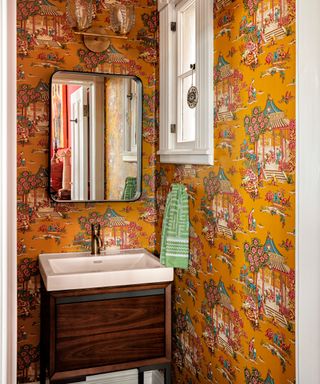 powder room with yellow chinoiserie wallpaper and wooden washstand