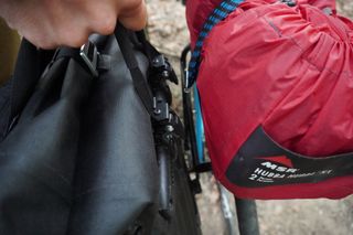 Image shows Stefan attaching the Ortlieb Vario PS pannier backpacks to the Old Man Mountain Divide Rack.