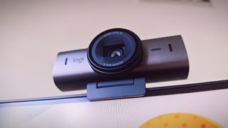 A Graphite-coloured Logitech MX Brio webcam sitting on top of a monitor