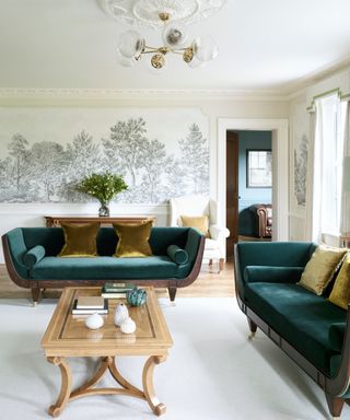 living room with landscape wall murals and teal velvet sofas