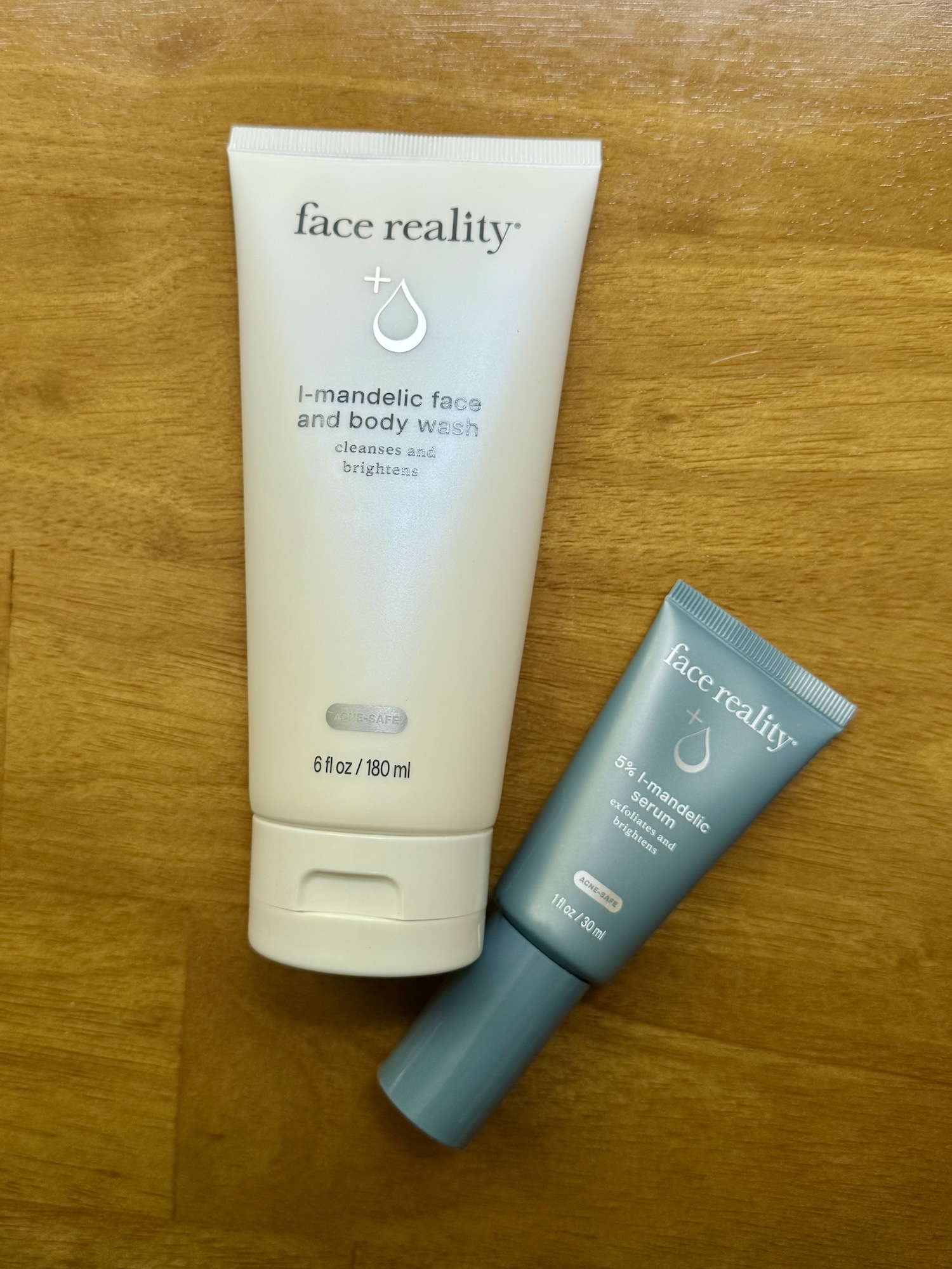 A bottle of Face Reality L-Mandelic Face and Body Wash alongside a tube of serum.