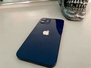 iPhone 12 Blue with a skull decoration in the background