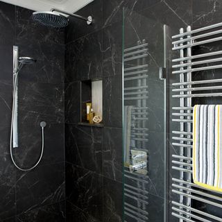 grey tiled shower area with towel rack