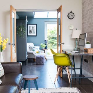 room with leather sofa set and desk with yellow chair