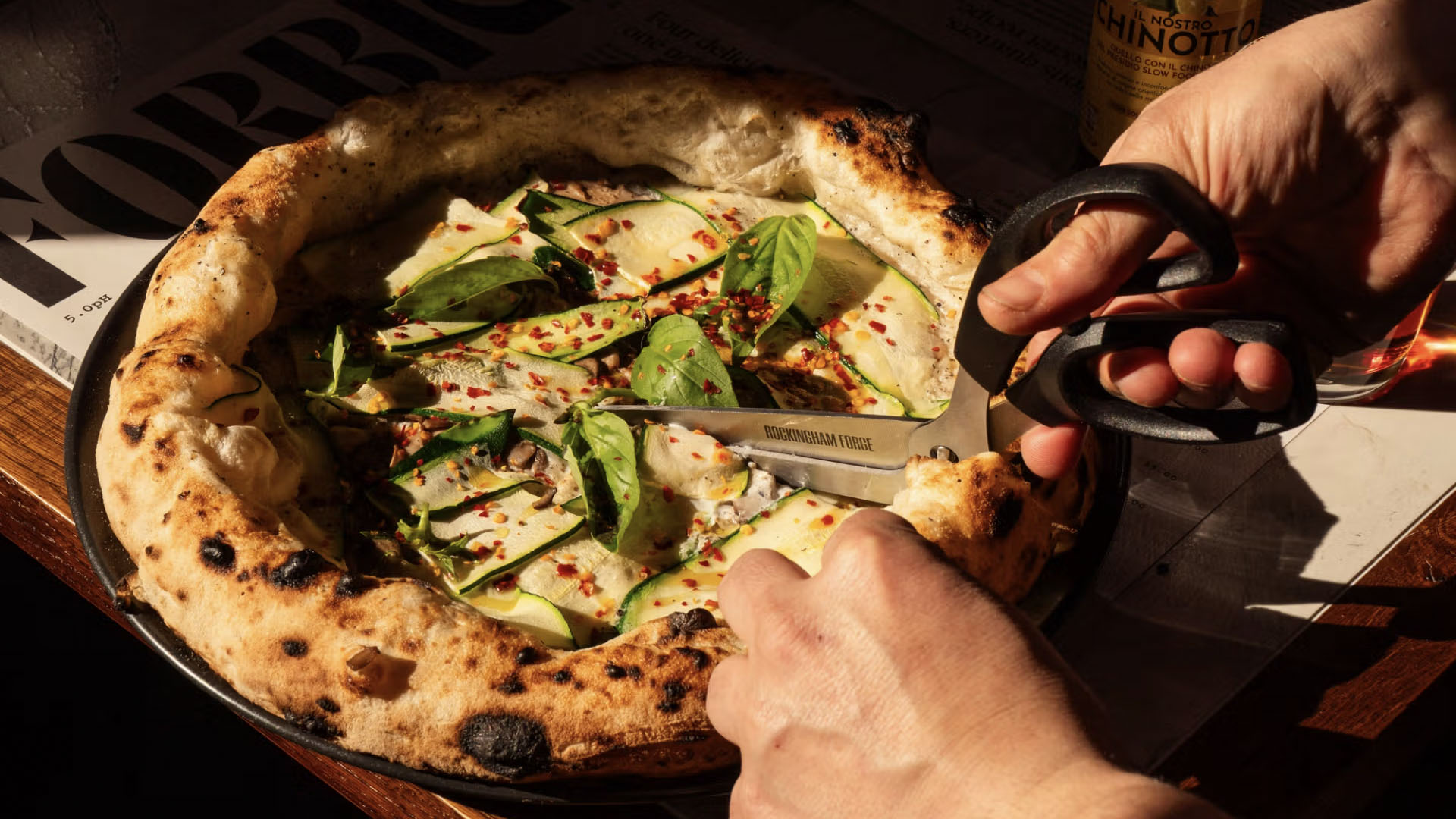A photo of a pizza being cut with scissors. 