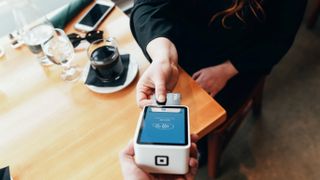 Person taps payment card on POS terminal