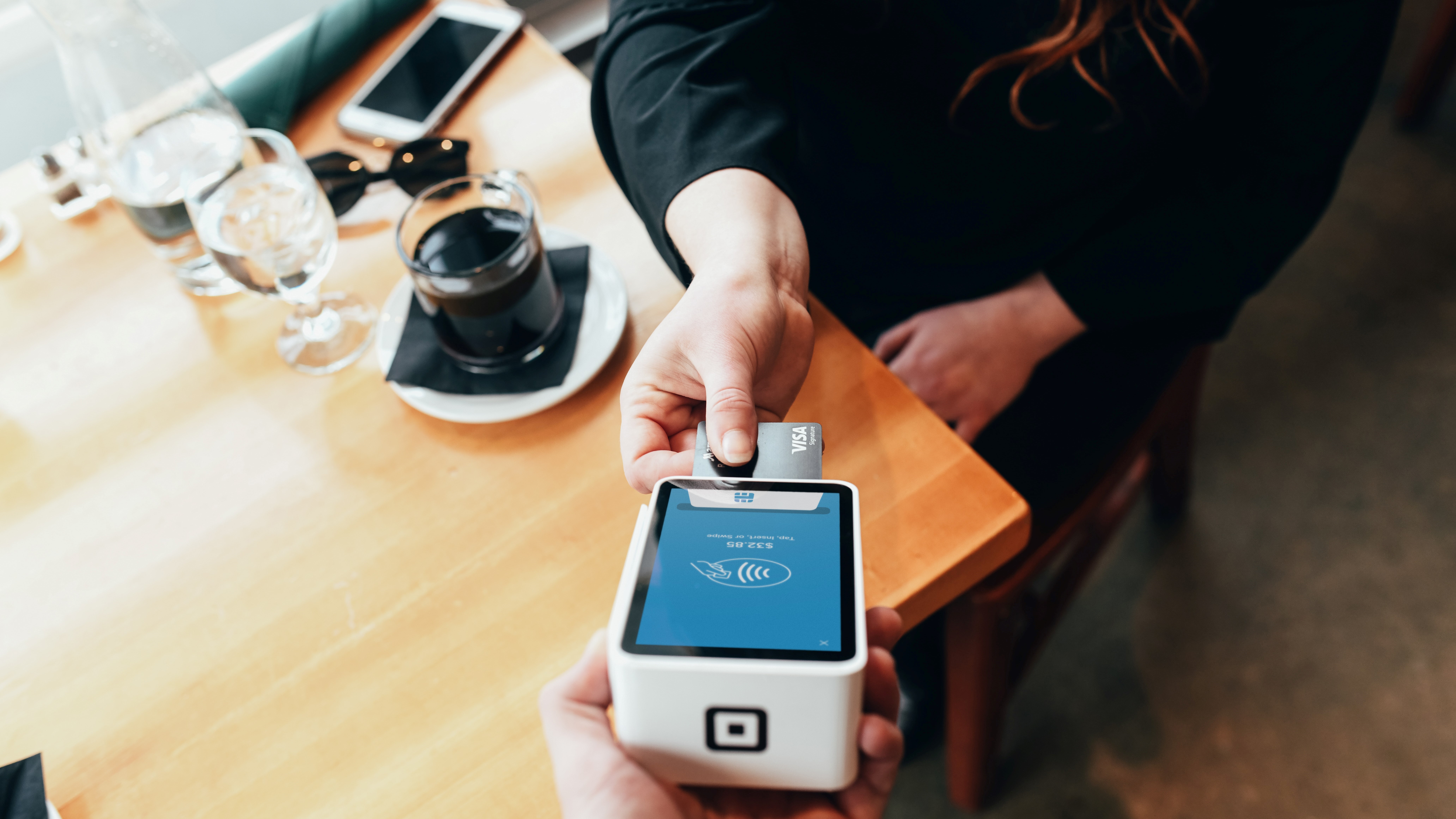 Woman taps payment card on card reader