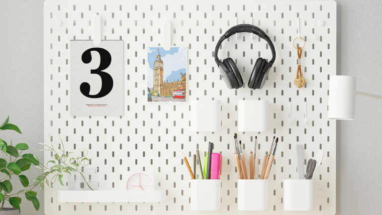 The IKEA pegboard used in a home office set up to organise stationary and equipment