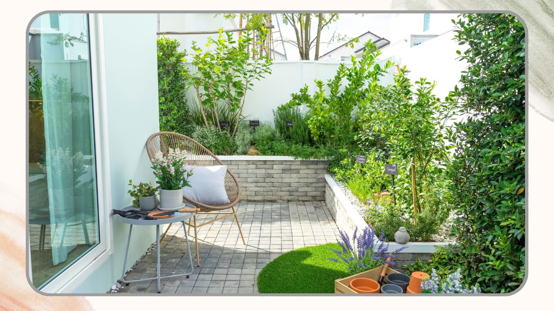 picture of small garden with walled border and white wooden fence