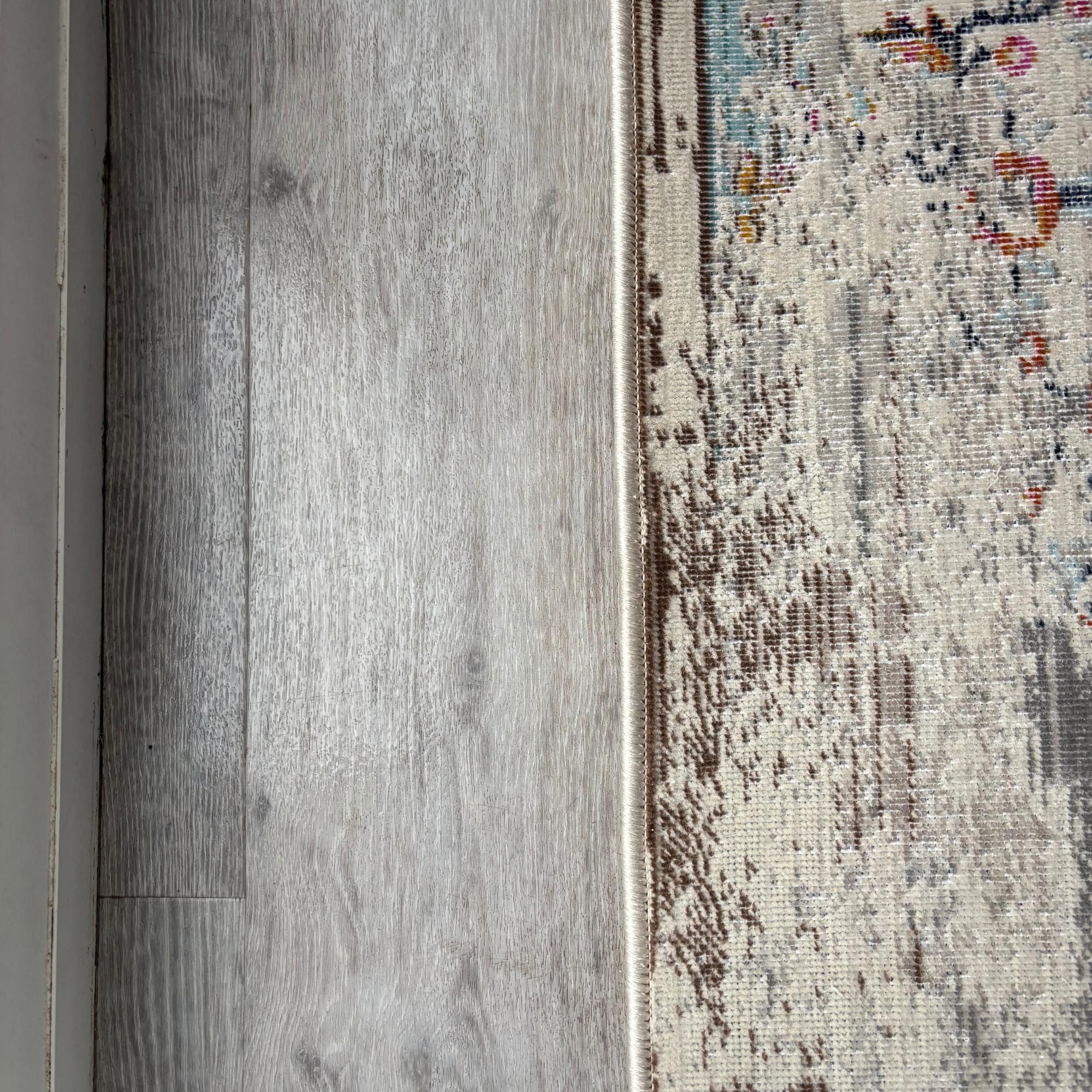 grey laminate floor pictured with rug, after being cleaned with the Shark Steam & Scrub Automatic