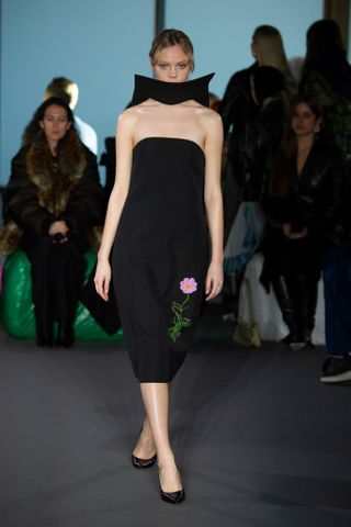 Woman on runway in Christopher Kane dress with structured board neck detail
