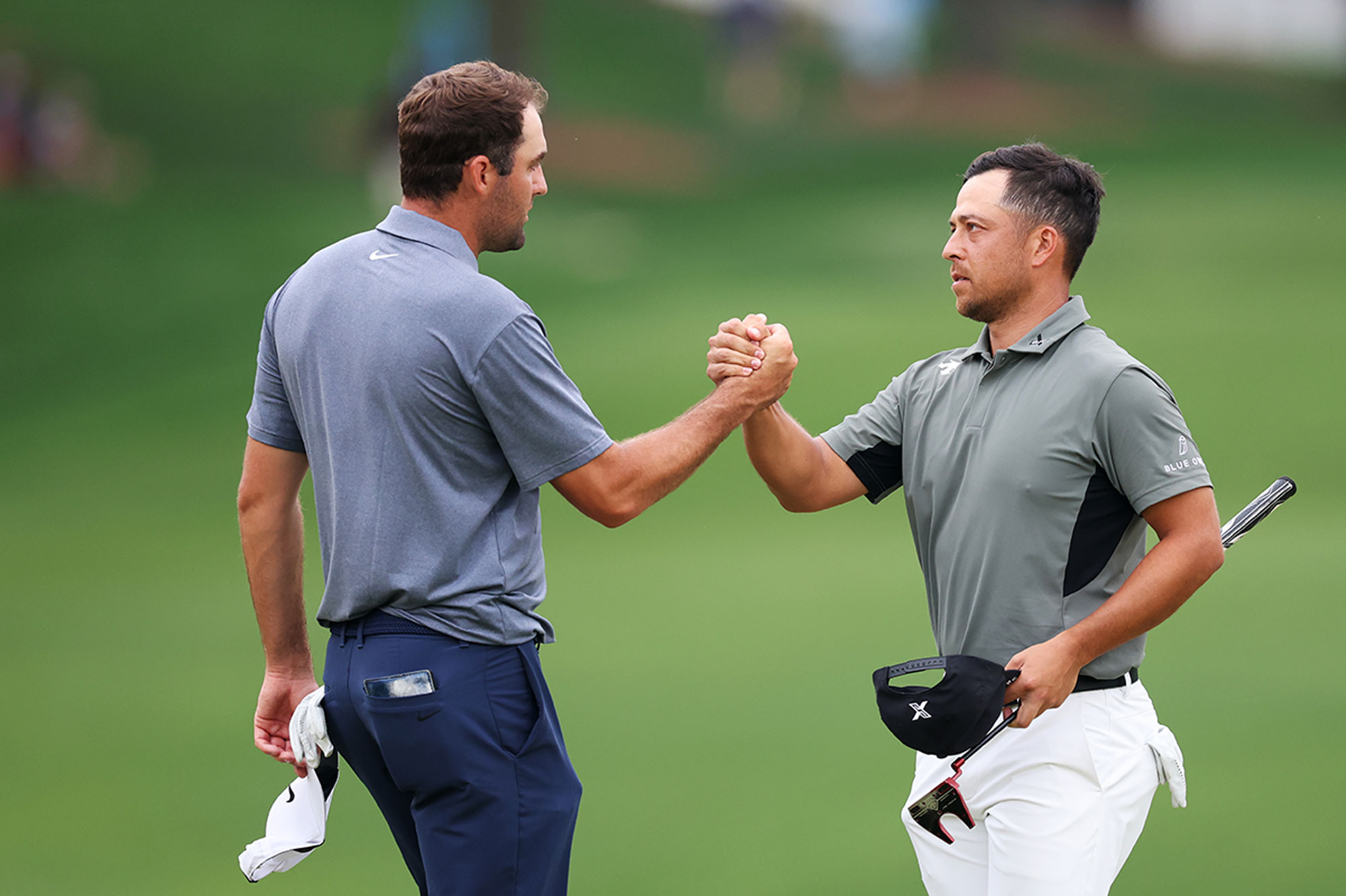 Scottie Scheffler and Xander Schauffele shaking hands after playing together at the 2025 PGA Championship, with Scottie eventually being crowned champion over defending title holder Schauffele