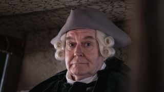 James Fleet in a white wig and grey hat as Squire Allworthy in Tom Jones.