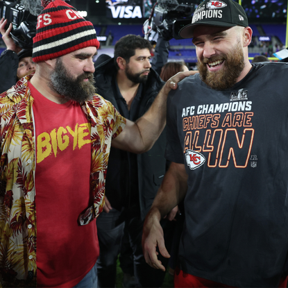 Travis Kelce #87 of the Kansas City Chiefs celebrates with his brother Jason Kelce after a 17-10 victory against the Baltimore Ravens in the AFC Championship Game at M&T Bank Stadium on January 28, 2024 in Baltimore, Maryland. 