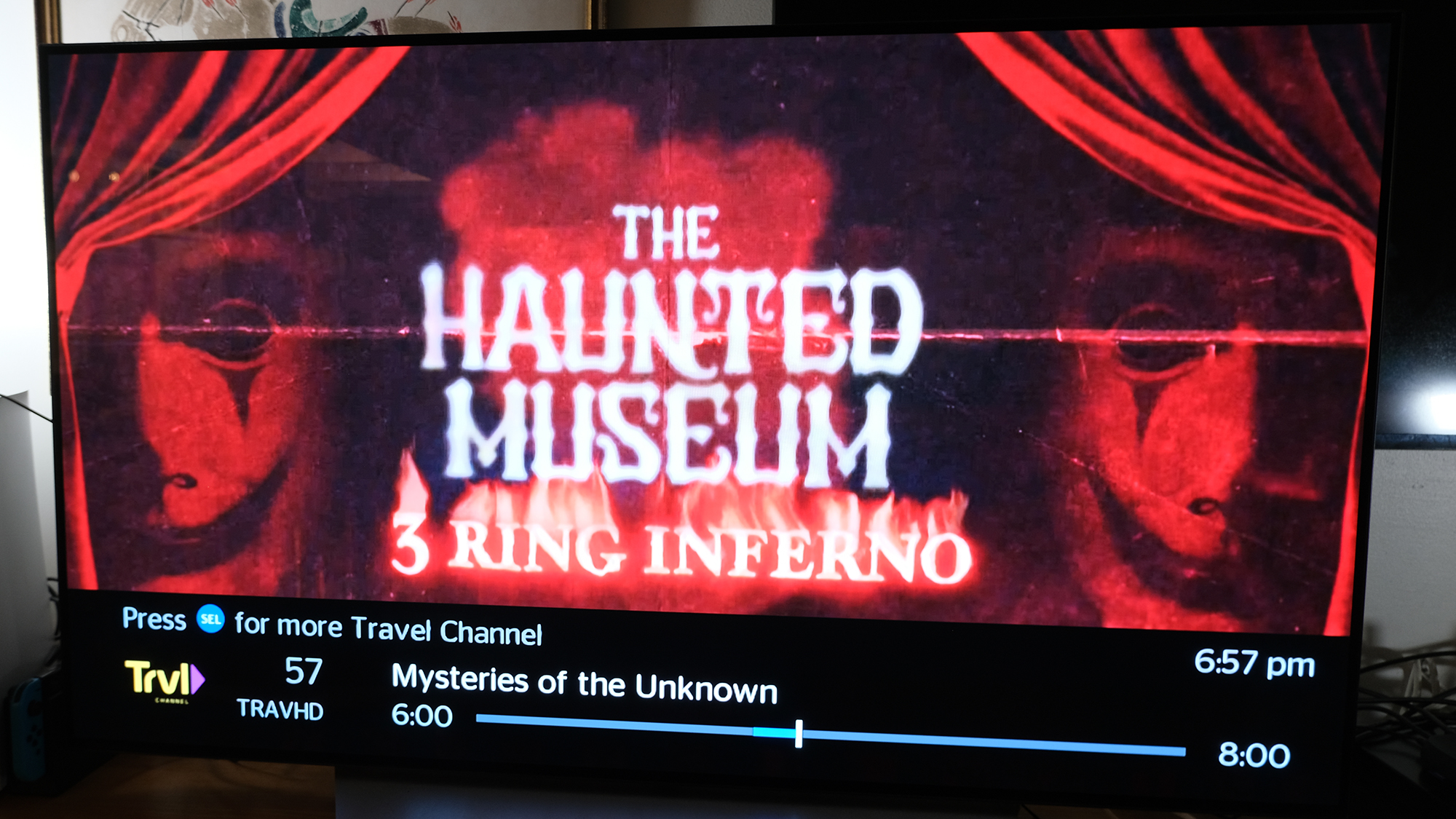 Un anuncio de Travel Channel para The Haunted Museum: 3 Ring Inferno en la televisión por cable se ve en un televisor conectado al Amazon Fire TV Cube (2022)