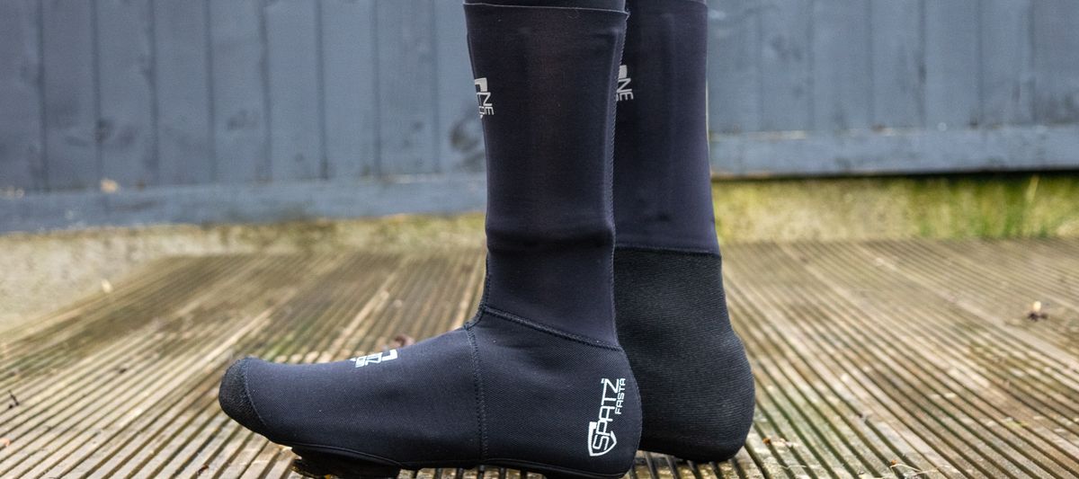 The Spatz Fasta overshoe beoing worn by a rider standing on a wooden deck