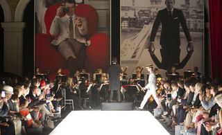 Orchestra played by the models' entrance to the catwalk, while large prints of 1960s images by photographer Terry O'Neill were installed in an exhibition space behind the catwalk.