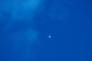 jupiter and mars appears as bright white spots of light against a deep blue sky.