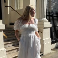Woman wears white dress and gold necklace