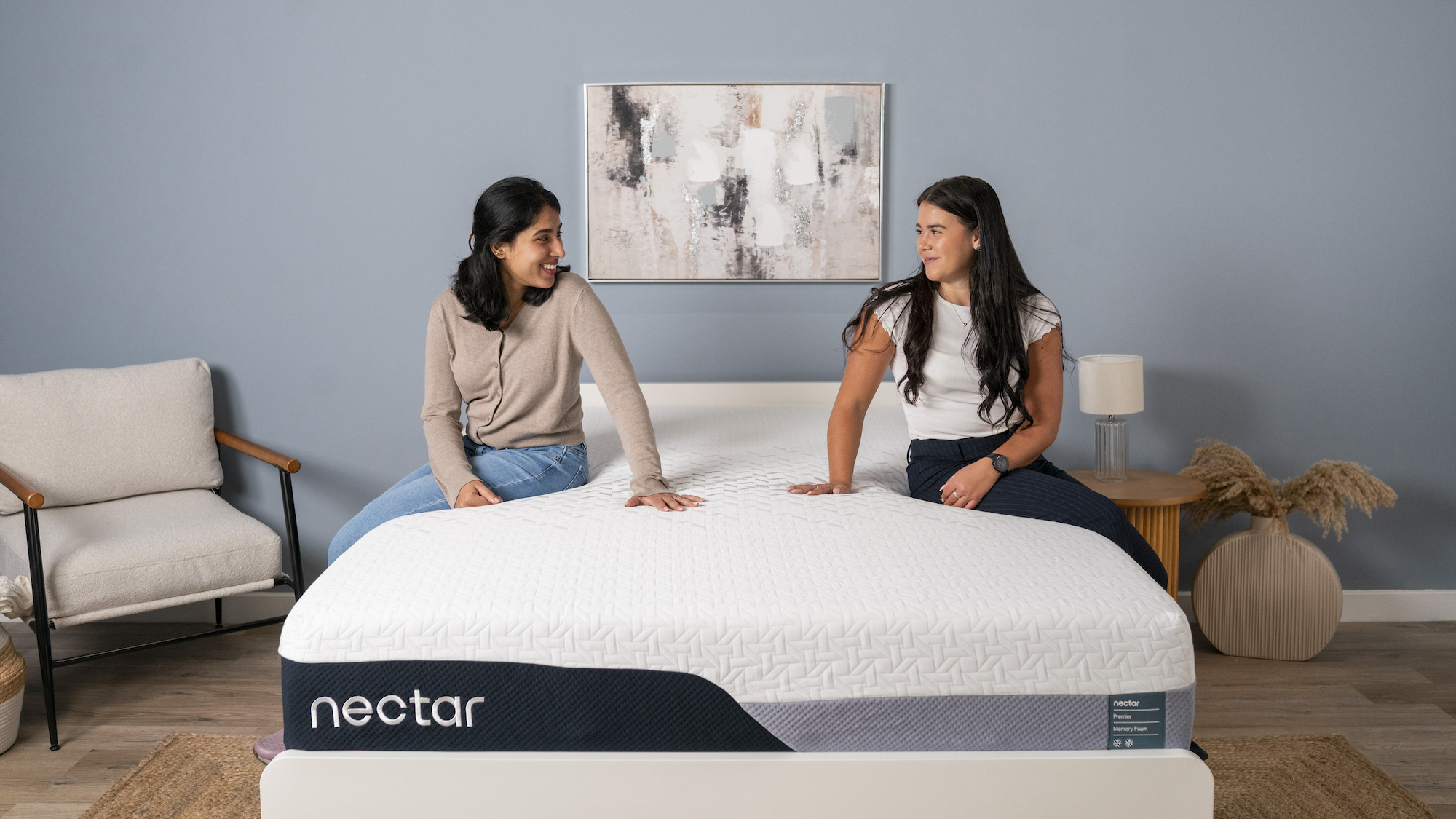 Sleep Staff Writers Becky George and Eve Davies sit on opposite sides of the Nectar Premier Memory Foam Mattress and discuss the motion isolation and pressure relief with our Managing Editor of Sleep Claire Davies who is just off camera