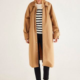 Balzac Paris trench coat on model with white and black stripe shirt and black jeans