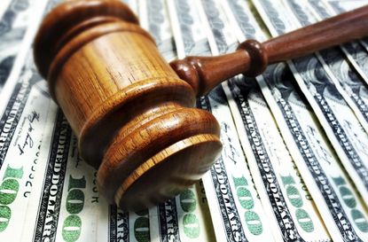 A judge's gavel sits on top of a pile of cash