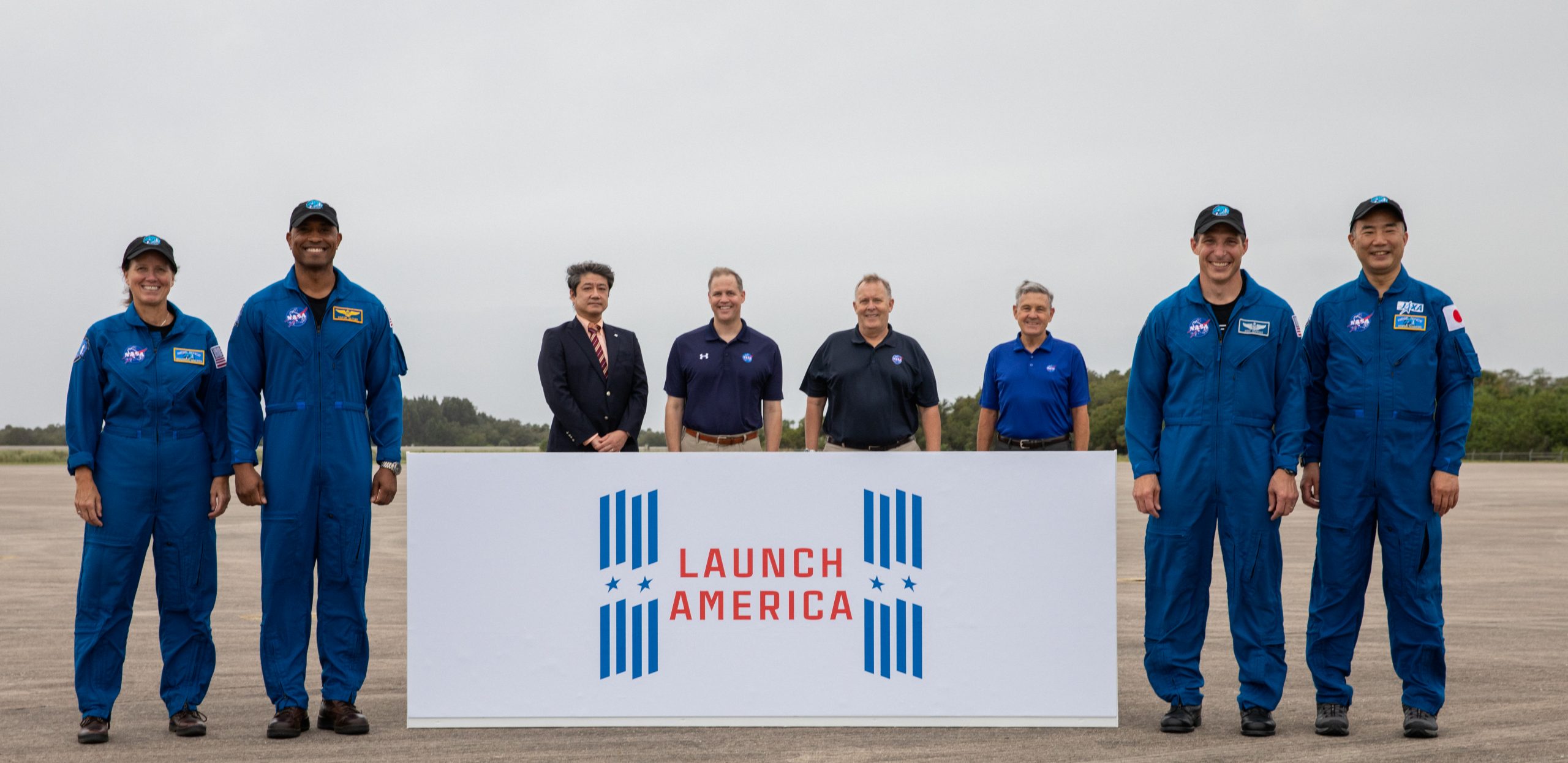 A crew arrival event for NASA’s SpaceX Crew-1 mission is held Nov. 8, 2020, at the Launch and Landing Facility at the agency’s Kennedy Space Center in Florida. From left are NASA astronaut Shannon Walker, mission specialist; NASA astronaut Victor Glover, pilot; Junichi Sakai, manager, International Space Station Program, JAXA; NASA Administrator Jim Bridenstine; NASA Deputy Administrator Jim Morhard; Bob Cabana, director, Kennedy Space Center; NASA astronaut Michael Hopkins, spacecraft commander; and JAXA astronaut Soichi Noguchi, mission specialist.