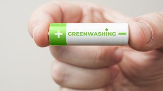 Close up of aosmeone hold a battery that says greenwashing