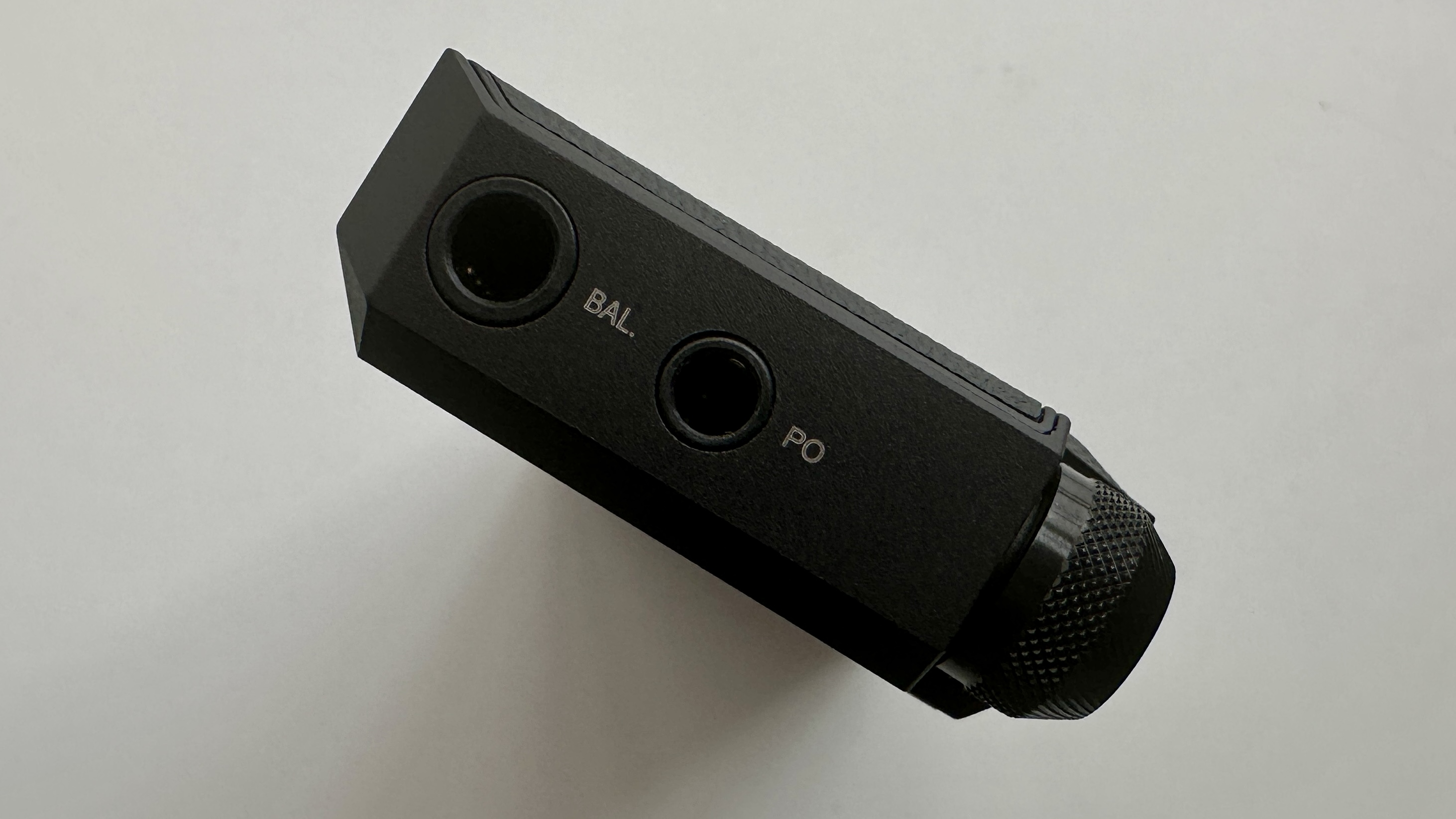 FiiO's BTR17 DAC/amp in black, on a gray table, showing PCM resolution in yellow font