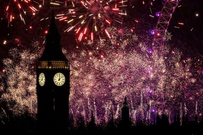 Fireworks explode in the sky around the London Eye and The Elizabeth Tower