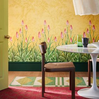 skirting board colour ideas, green skirting board, dining room with wall mural, white table with retro chairs, green patterned rug