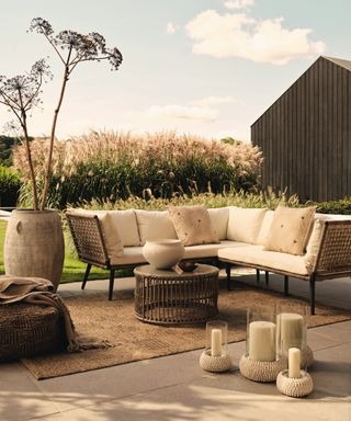 Patio furniture with coir rug, large planter, rattan coffee table, hurricane lamps