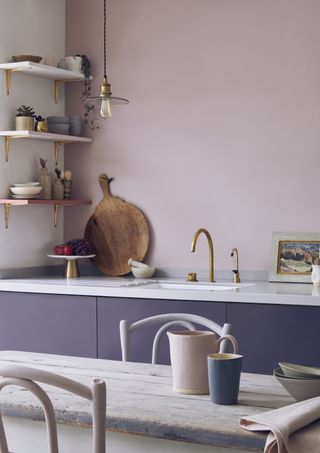 pink kitchen with lilac cabinetry, open plan shelving, kitchen table
