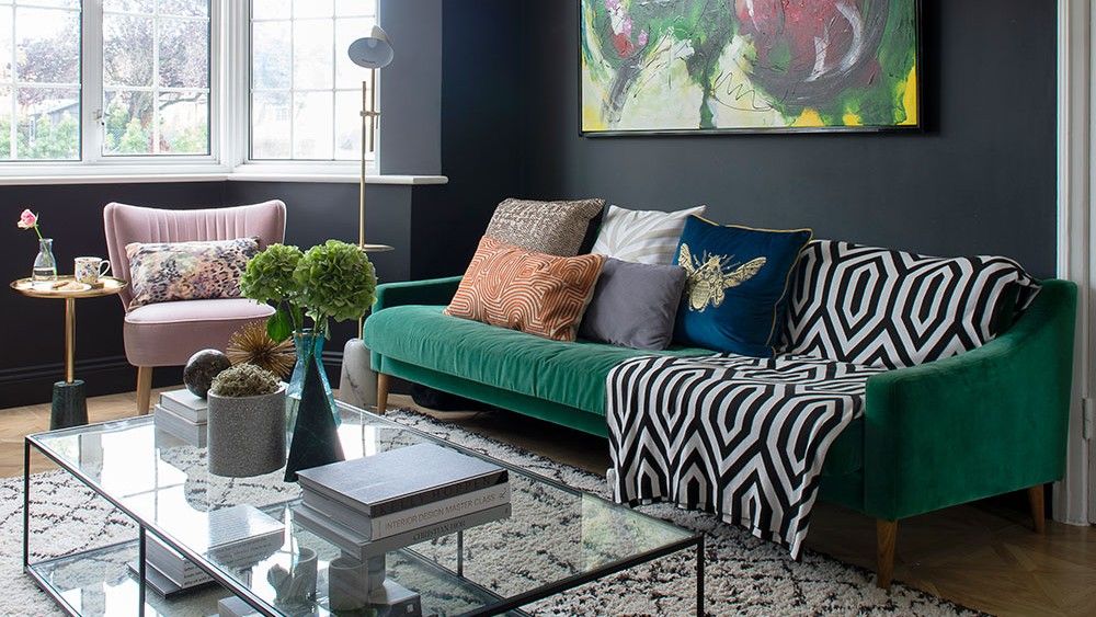 living room with green sofa set and glass teapoy with white long curtains