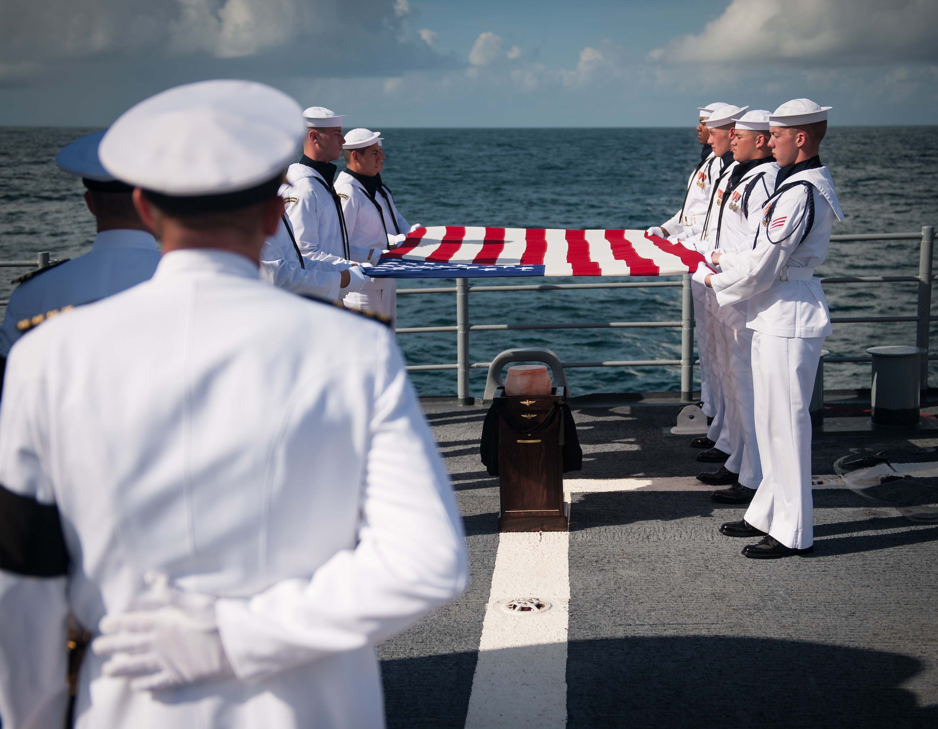 Members of the US Navy ceremonial guard hold an American flag over the cremains of Apollo 11 astronaut Neil Armstrong during a burial at sea service aboard the USS Philippine Sea (CG 58), Friday, Sept. 14, 2012, in the Atlantic Ocean. Armstrong, the first man to walk on the moon during the 1969 Apollo 11 mission, died Saturday, Aug. 25. He was 82.
