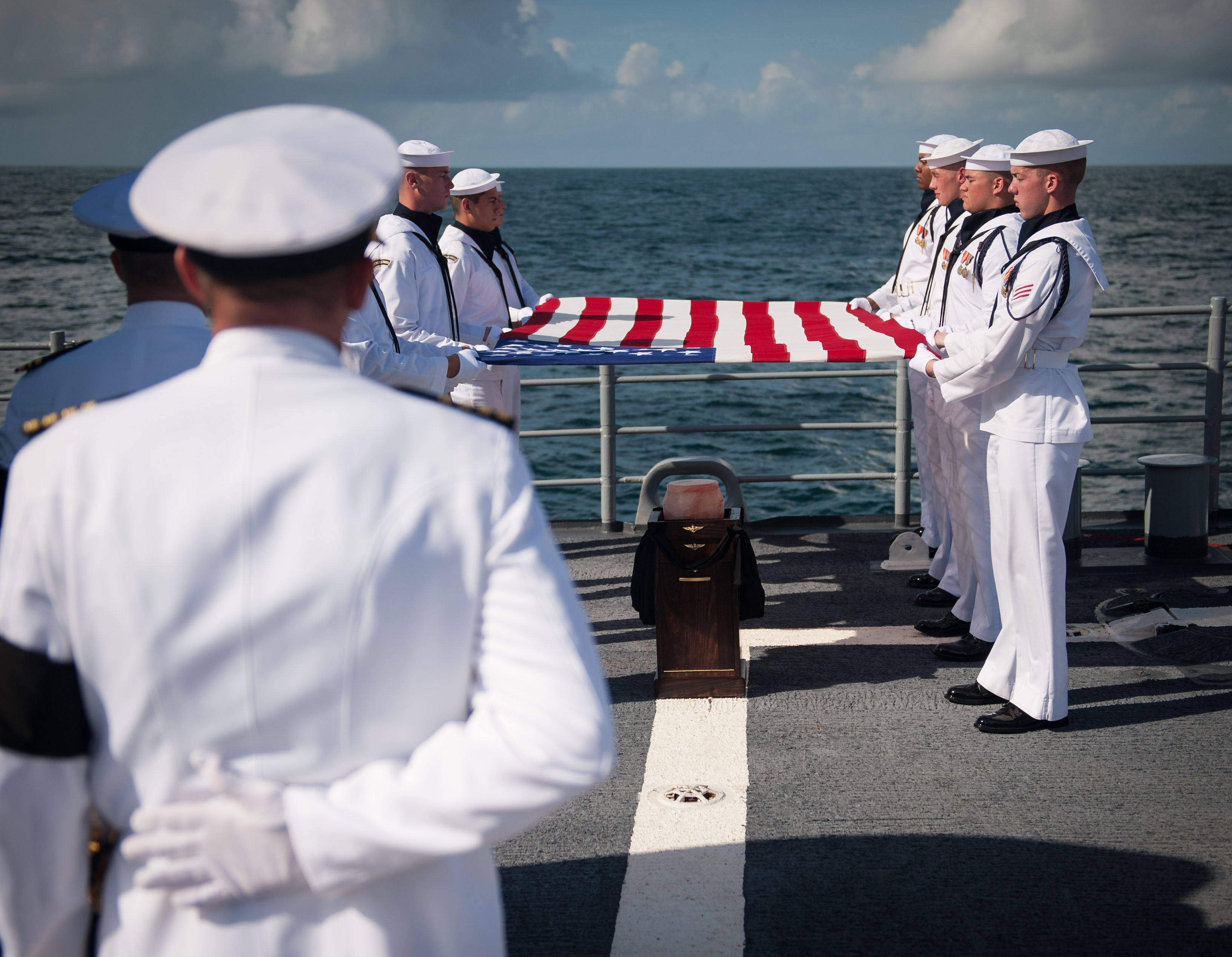 Członkowie Gwardii Ceremonialnej Marynarki Wojennej USA niosą amerykańską flagę nad krematorium astronauty Apollo 11, Neila Armstronga, pochowanego w służbie morskiej na pokładzie USS Philippine Sea (CG 58), piątek, 14 września 2012 r. na Oceanie Atlantyckim.  Armstrong, pierwszy człowiek, który chodził po Księżycu podczas misji Apollo 11 w 1969 roku, zmarł w sobotę 25 sierpnia.  Miał 82 lata.