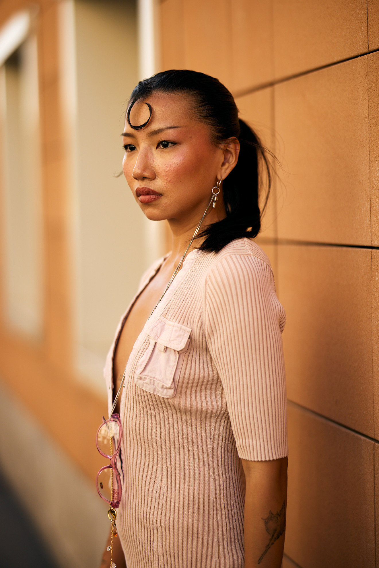 an asian woman in a pink knit top with a black kiss curl
