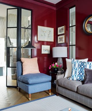 Crimson painted living space with blue soft furnishings