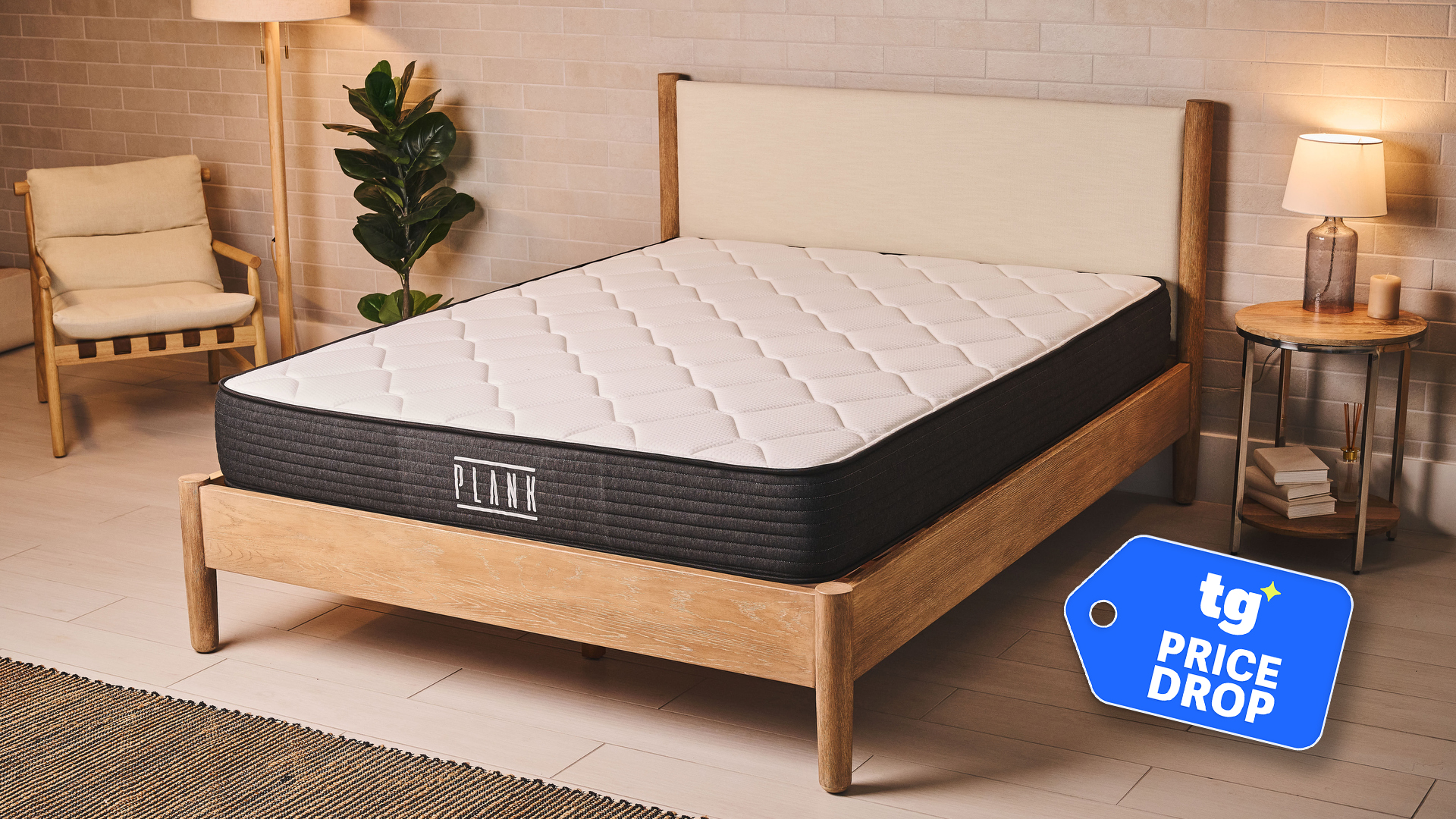 The Plank Firm Mattress on a bed frame in a bedroom. In the bottom right corner is a Tom's Guide price drop badge