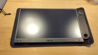 An ASUS ZenScreen MB166CR portable monitor sitting on a desk