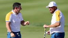 Rory McIlroy and Shane Lowry of Team Europe interact on the first green during a practice round prior to the 2023 Ryder Cup at Marco Simone Golf Club on September 26, 2023.