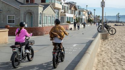 People ride e-bikes on the beach in Hermosa Beach, California.