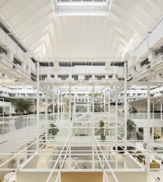 Overview of white grids with transparent frame and planting at Sid Lee’s international hq, high white ceiling with arch design, skylight