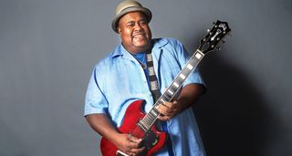 Larry McCray smiles as he plays his red Guild Polara