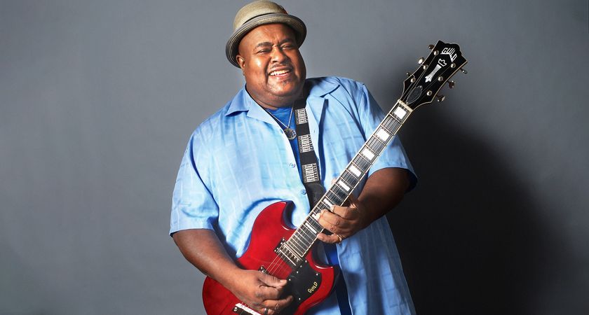 Larry McCray smiles as he plays his red Guild Polara