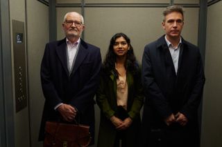 Richard (Jim Broadbent), Misha (Hiftu Quasem) and Jonathan (Jack Davenport) stand side by side in a lift. Jonathan looks mildly annoyed.