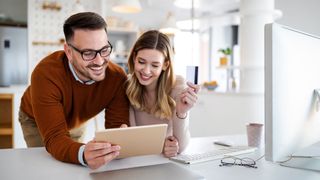 Young couple using payment card on a tablet